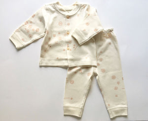2 piece baby girl clothing set in cream with dainty pink print.  The set includes a button up top with matching pull on pants.  It is made from super soft GOTS certified organic cotton.