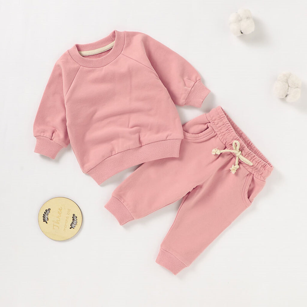 2 piece baby girl sweatsuit set in pink.  The set includes a sweatshirt and matching joggers.  It is made from soft GOTS certified organic cotton.